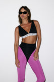 Woman wearing a black and pink sports outfit with 'HEROS' branding on a white background